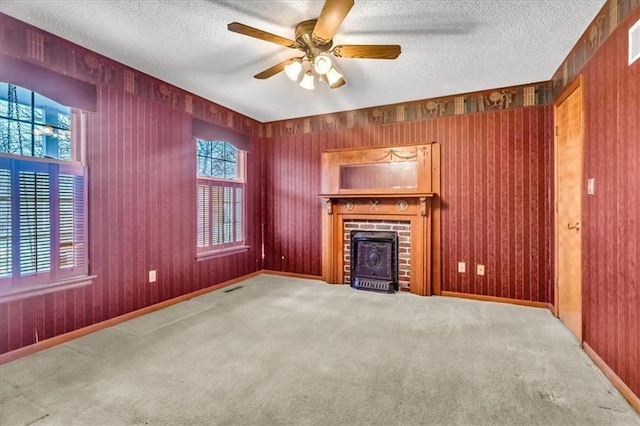 unfurnished living room with a fireplace, a textured ceiling, carpet floors, and ceiling fan