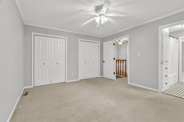 unfurnished bedroom with ensuite bathroom, ceiling fan, light colored carpet, and crown molding