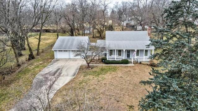 view of front of house featuring covered porch, a garage, and a front yard