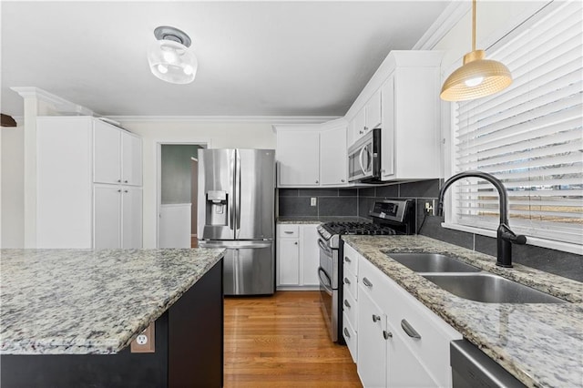 kitchen featuring tasteful backsplash, sink, white cabinets, and stainless steel appliances