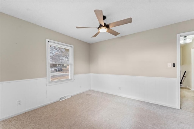 carpeted spare room featuring ceiling fan