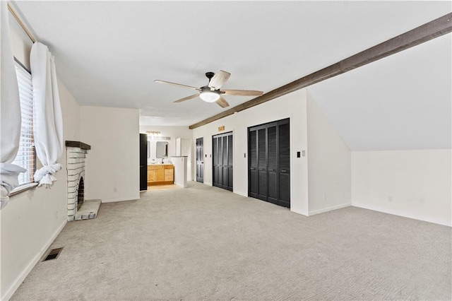 unfurnished living room with a brick fireplace, ceiling fan, light carpet, and vaulted ceiling