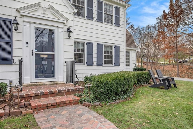 view of exterior entry with a yard