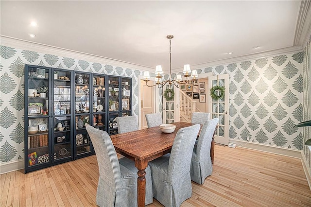 dining space featuring light wood-type flooring, an inviting chandelier, and crown molding