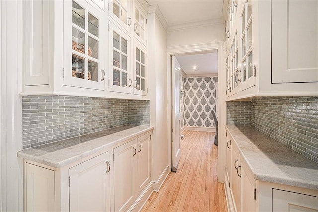 bar with ornamental molding, tasteful backsplash, and white cabinetry