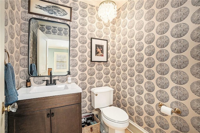 bathroom featuring toilet, vanity, and ornamental molding