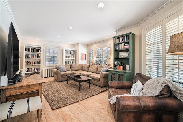 living room featuring hardwood / wood-style floors, crown molding, and radiator