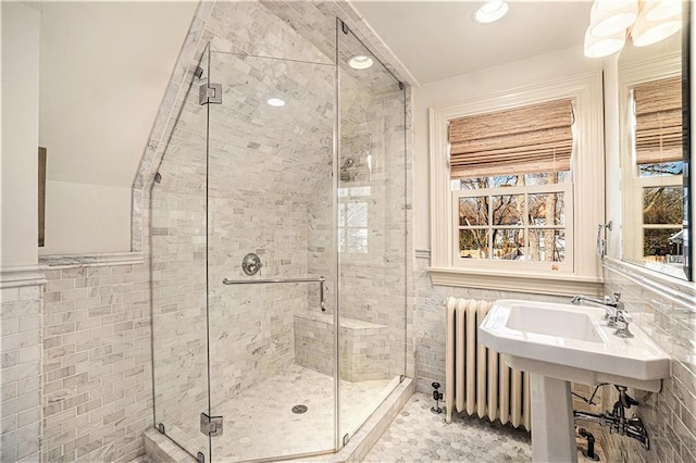 bathroom with tile walls, walk in shower, tile patterned floors, and radiator