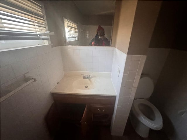 bathroom with vanity, tile walls, and toilet