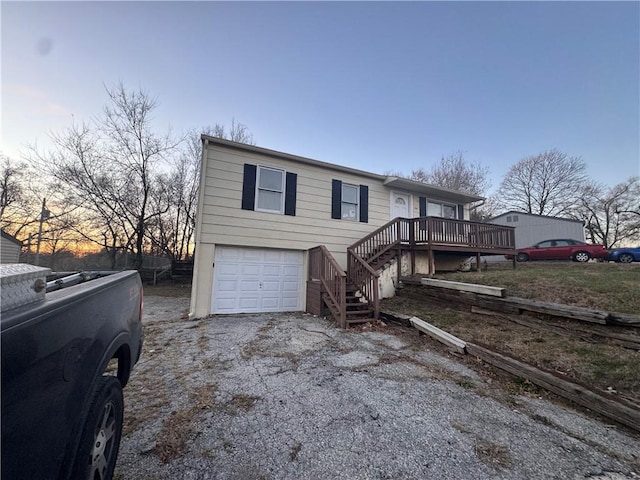 view of front facade with a garage and a wooden deck