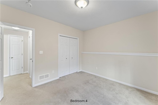 unfurnished bedroom featuring light colored carpet, a closet, visible vents, and baseboards