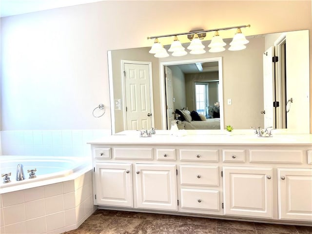 full bathroom with double vanity, a garden tub, ensuite bath, and a sink