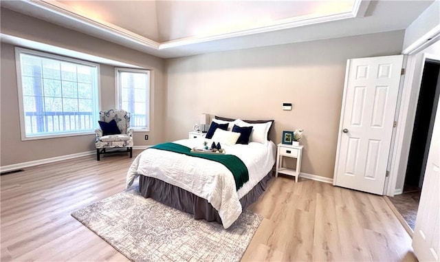 bedroom with light wood finished floors, visible vents, and baseboards