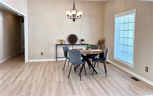 dining area with light wood-type flooring, visible vents, baseboards, and an inviting chandelier