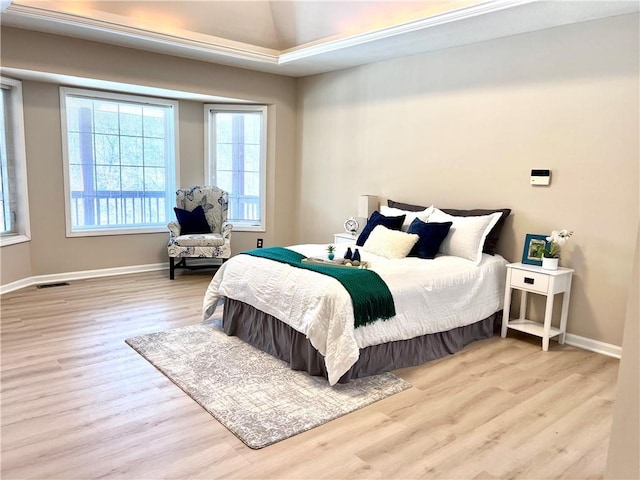 bedroom featuring visible vents, lofted ceiling, light wood-style flooring, and baseboards