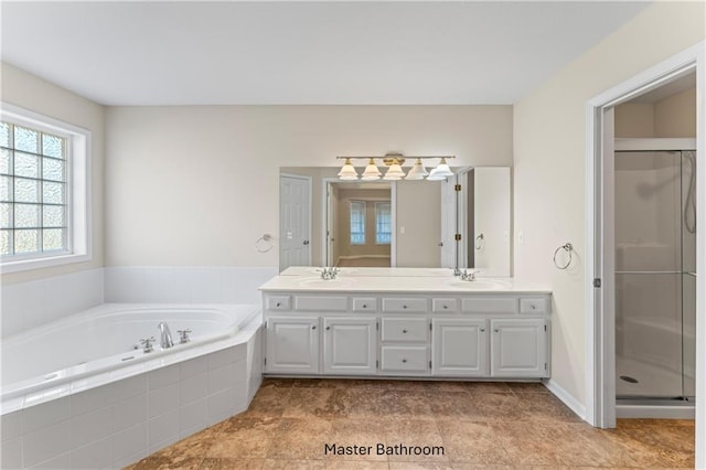 full bath featuring double vanity, a stall shower, a sink, and a bath