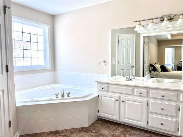 bathroom with a garden tub and vanity