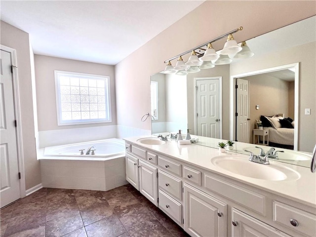 bathroom with ensuite bathroom, double vanity, a sink, and a bath