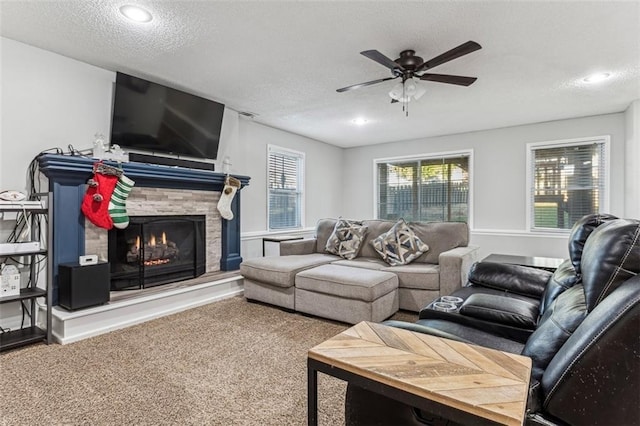 living room with carpet flooring, ceiling fan, and a textured ceiling