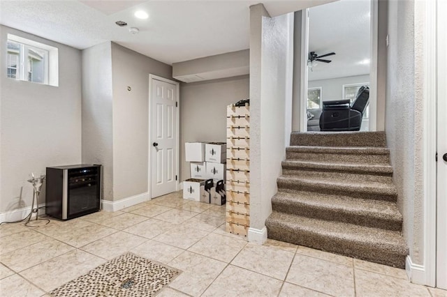 staircase with tile patterned floors, ceiling fan, and plenty of natural light