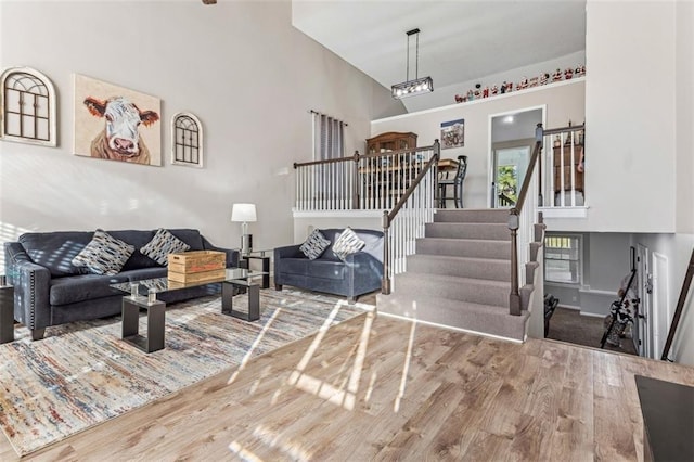 living room with hardwood / wood-style floors and high vaulted ceiling