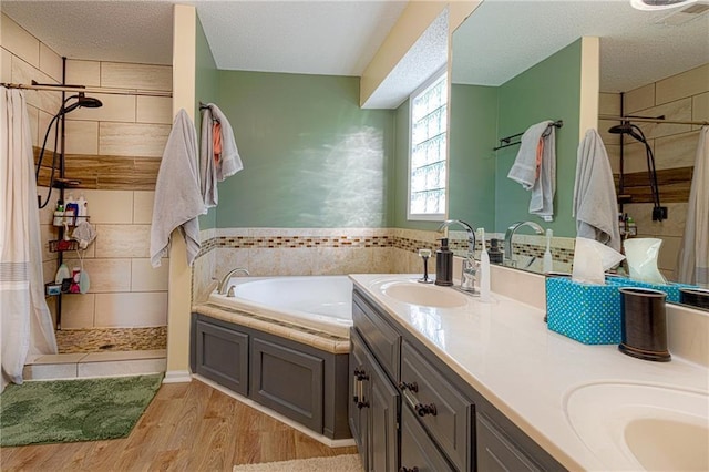 bathroom featuring vanity, wood-type flooring, a textured ceiling, and independent shower and bath