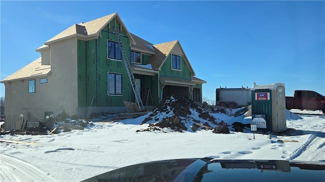 snow covered property with a garage