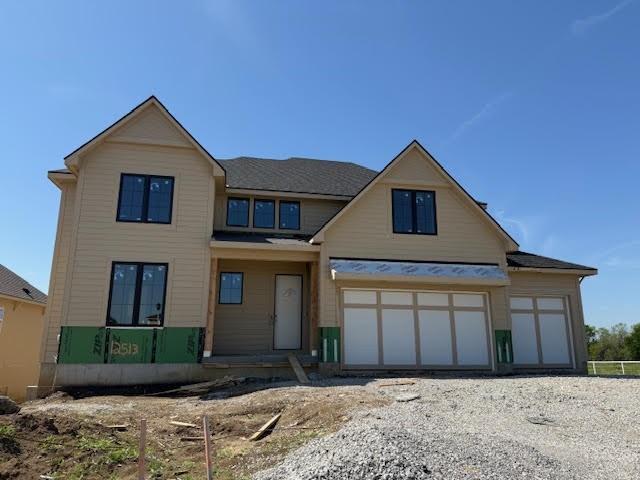view of front of home featuring a garage and gravel driveway