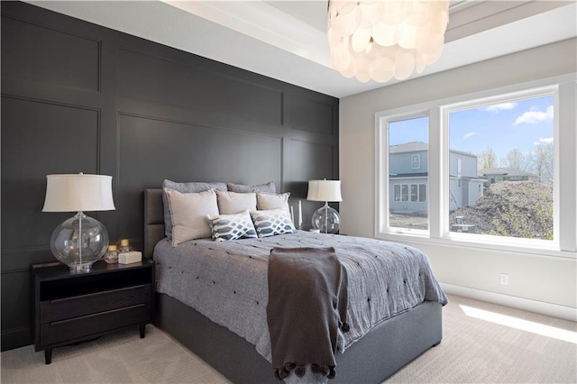 bedroom with light carpet, a decorative wall, and baseboards