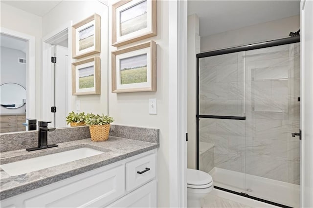 bathroom with toilet, a shower stall, and vanity