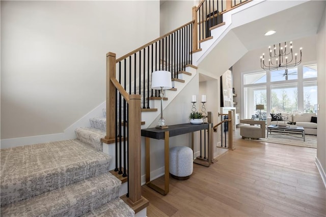 12513 W 184th St, Overland Park, KS 66013 - stairway with a high ceiling, wood finished floors, a chandelier, baseboards, and recessed lighting