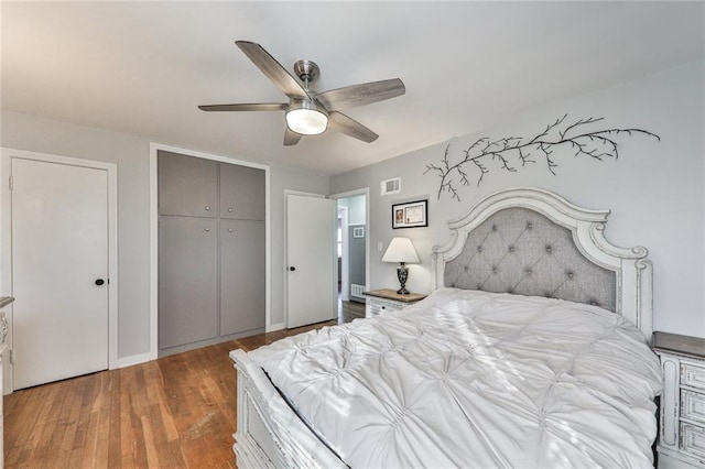 bedroom featuring hardwood / wood-style flooring, ceiling fan, and a closet