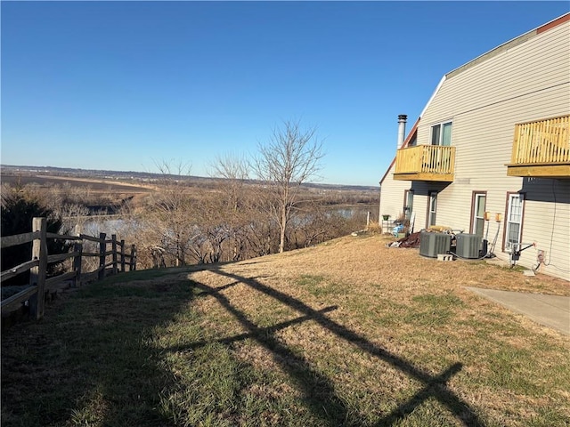 view of yard featuring a balcony and central AC unit