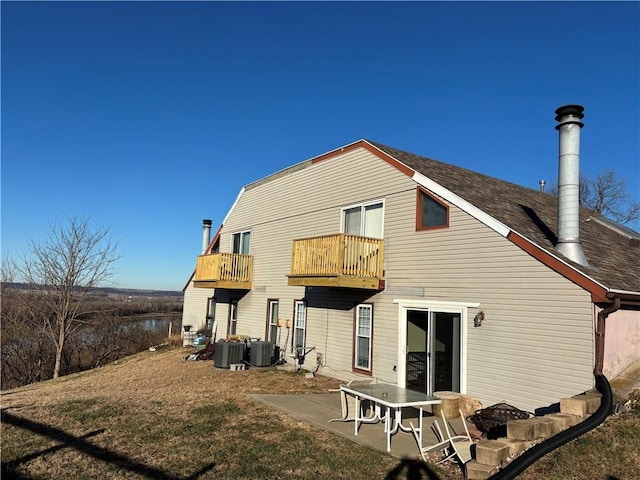 rear view of property featuring a balcony, cooling unit, and a patio area