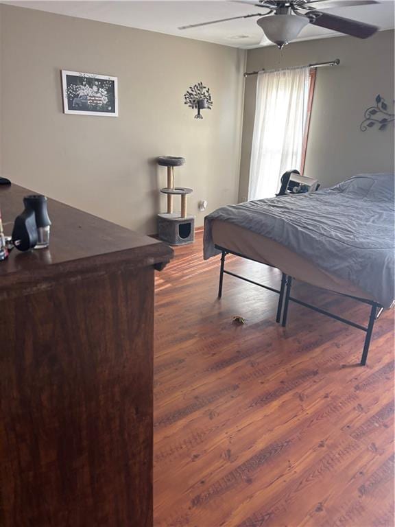 bedroom featuring ceiling fan and dark wood-type flooring