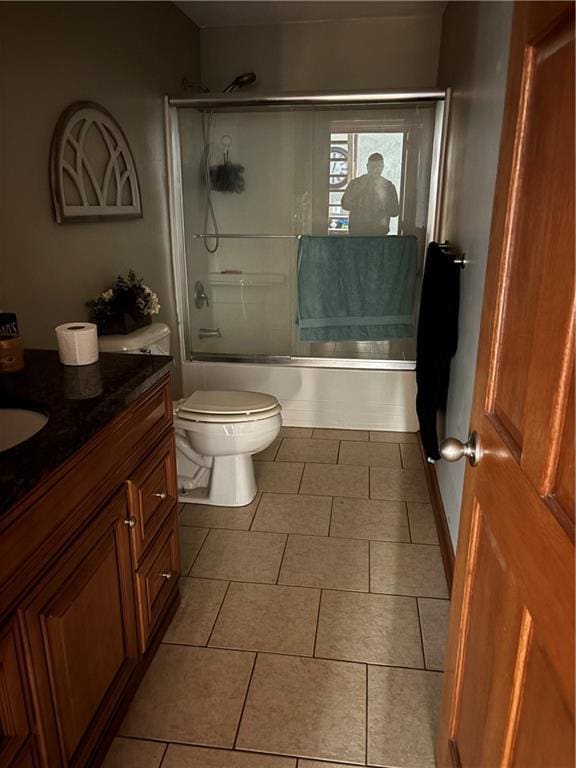 full bathroom with tile patterned flooring, vanity, toilet, and bath / shower combo with glass door