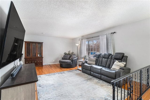 living room with a textured ceiling, baseboard heating, and hardwood / wood-style flooring