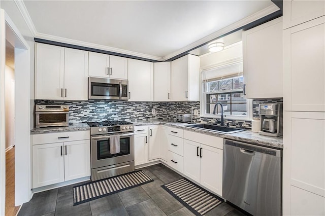 kitchen with white cabinetry, appliances with stainless steel finishes, backsplash, light stone counters, and sink