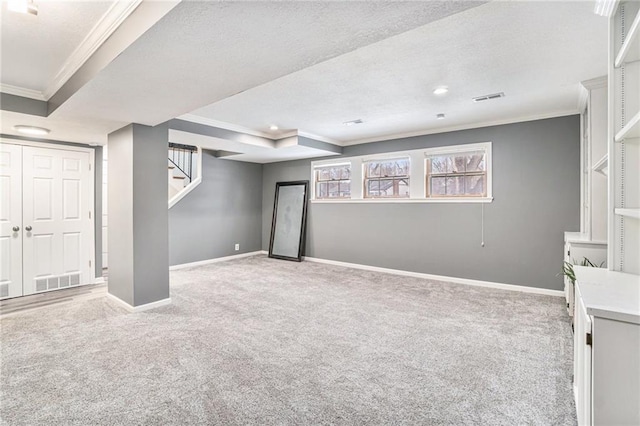 basement featuring light carpet, ornamental molding, and a textured ceiling