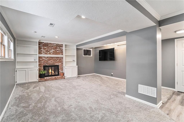 unfurnished living room featuring a textured ceiling, light carpet, crown molding, and a fireplace