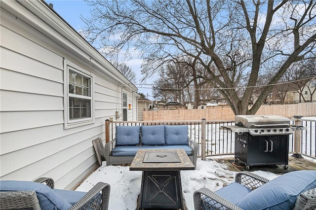 snow covered patio featuring an outdoor fire pit and grilling area