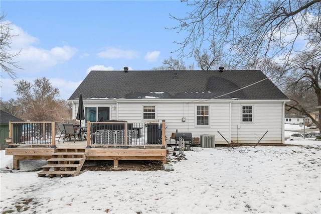 snow covered house featuring central AC and a wooden deck