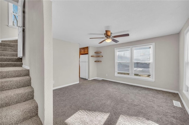 unfurnished living room featuring carpet and ceiling fan