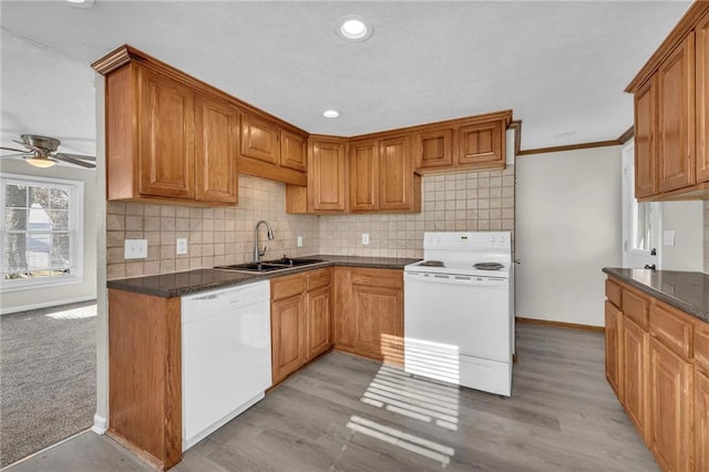 kitchen with white appliances, backsplash, sink, ornamental molding, and light hardwood / wood-style floors