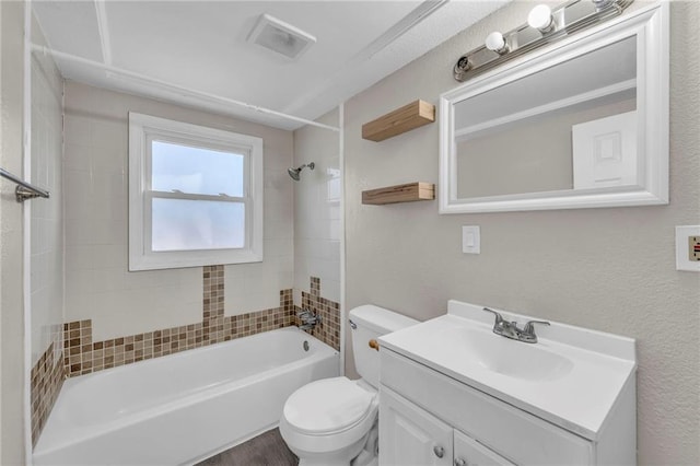 full bathroom with toilet, vanity, and tiled shower / bath