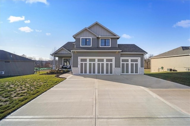 craftsman house with a garage and a front lawn