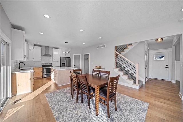 dining area with light hardwood / wood-style floors and sink