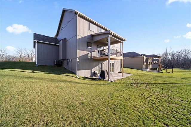 rear view of property with a yard, a balcony, and a patio