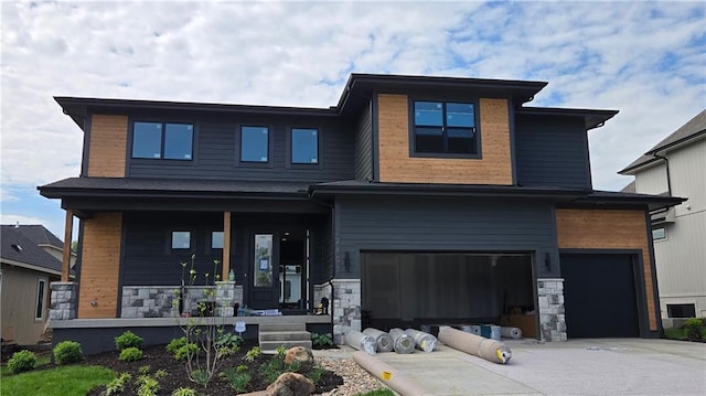 view of front of property with a porch, a garage, stone siding, and concrete driveway
