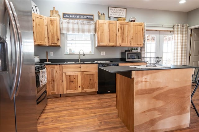 kitchen featuring a center island, stainless steel appliances, plenty of natural light, and sink